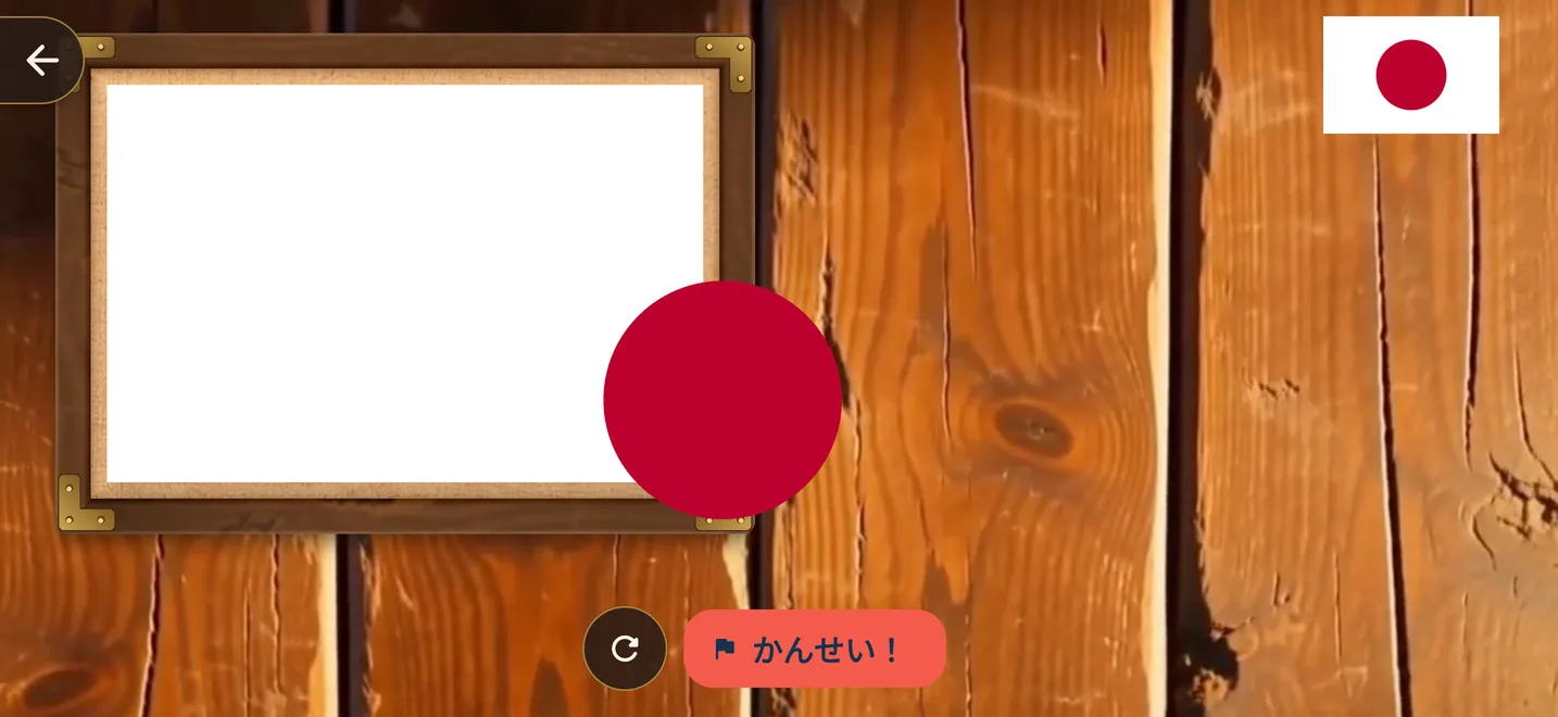 木の板の上で、白い旗の枠へ赤い丸のパーツを運ぶ、日本の国旗の組み立て画面